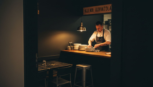 Ravintolan keittiömestari työskentelee tilassa, jossa on näyttävä syvänmusta tehosteseinä.