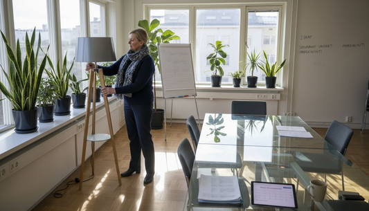 Nainen säätää valaistusta valoisassa kulmatoimistossa.